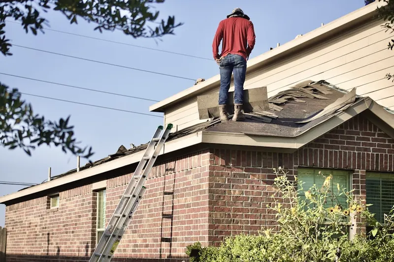 Professional roofer working on a residential roof in Carriage Place